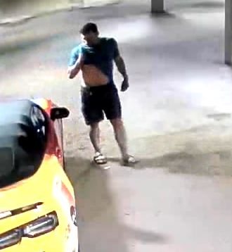 The man walking behind a yellow vehicle carrying emergency-light markings.
